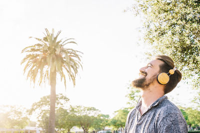 Portrait of young man looking away against sky