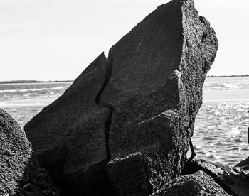 Close-up of rock on beach against clear sky