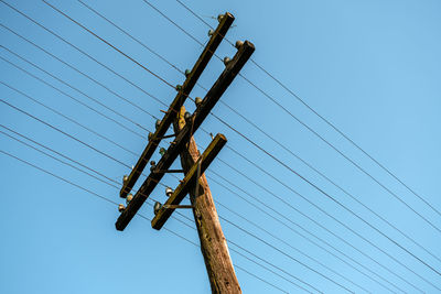 Low angle view of electricity pylon against sky