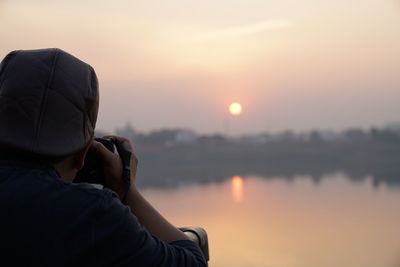 Midsection of man against sky during sunset