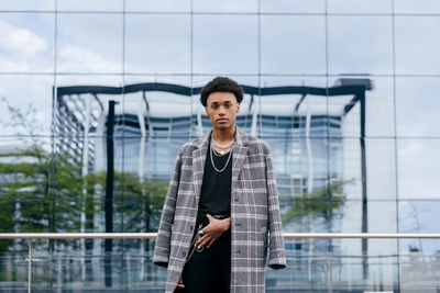 Portrait of young man standing against wall