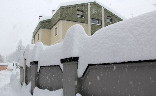 Snow covered houses by building