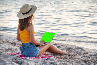 Young woman sitting at beach