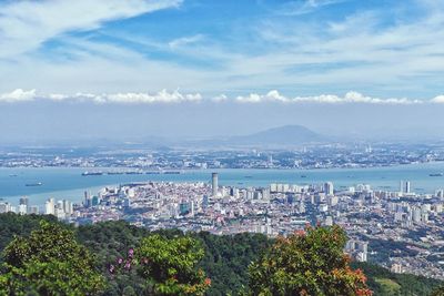 High angle view of city by sea against sky