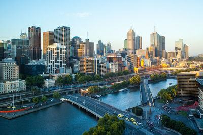 Aerial view of bridge over river by buildings in city