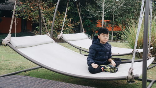 Portrait of boy sitting on hammock