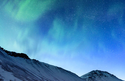 Scenic view of snowcapped mountains against sky at night