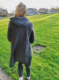 Rear view of woman standing on field