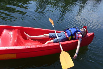 Worn out, child lying down in canoe on a hot summers day