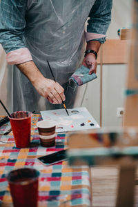 Midsection of man working on table