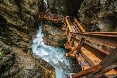 Wooden hike trail path inside a gorge with bue mountain river, sigmund thun klamm, kaprun, austria.