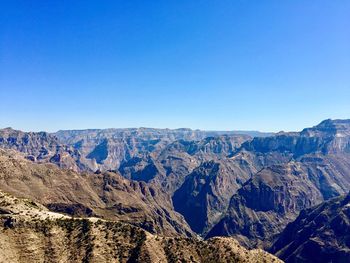 Panoramic view of mountains against clear blue sky