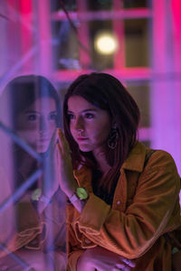 Reflection of young woman on glass