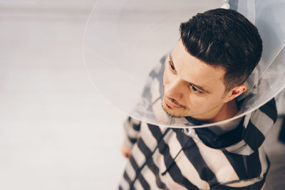 High angle view of man wearing protective collar by wall