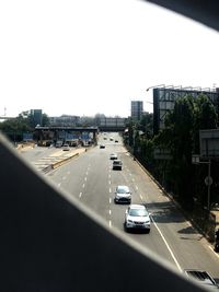 Traffic on road in city against clear sky