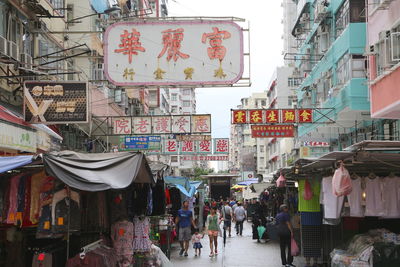 People on street amidst buildings in city