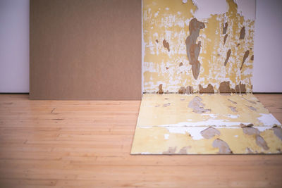 Close-up of bread on wooden table against wall