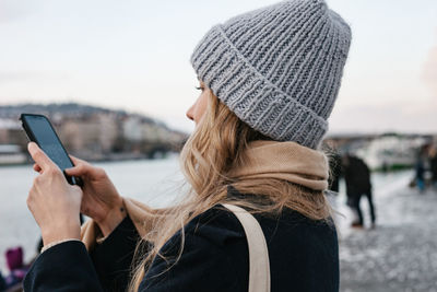 Portrait of woman holding mobile phone in winter