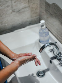 Close-up of hand in bathroom at home