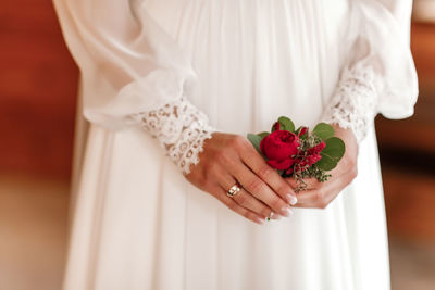 Midsection of bride holding bouquet