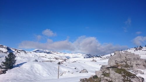 Scenic view of snowcapped mountains against blue sky