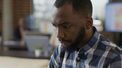 Young man with beard sitting in office