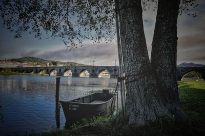 Bridge over calm river against sky