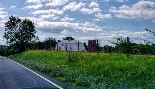 Road by field against sky