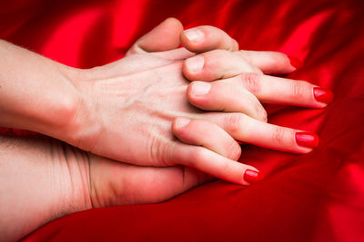 Close-up of woman touching red hand