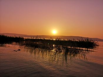 Scenic view of lake against romantic sky at sunset