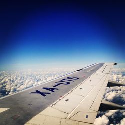 Airplane wing against clear blue sky