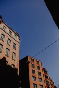 Low angle view of buildings against clear blue sky