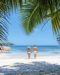 Rear view of woman standing at beach