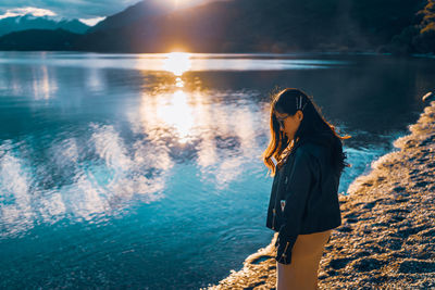 Rear view of woman standing at sea shore