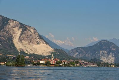 Scenic view of sea with village and mountain in background