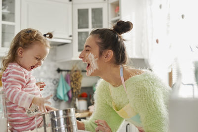 Rear view of mother and daughter at home
