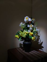 Close-up of potted plant on table against wall