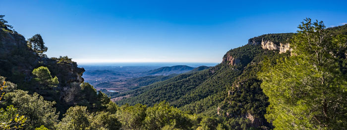 Scenic view of mountains against clear blue sky