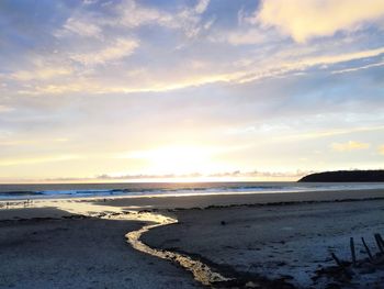 Scenic view of beach against sky during sunset