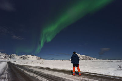 Rear view of man walking on snow