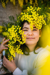 Portrait of woman holding yellow flower