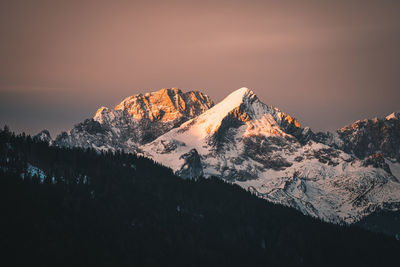 Scenic view of snowcapped mountains against sky during sunset