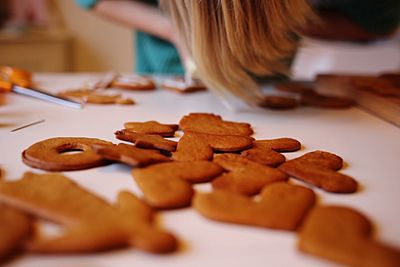 Midsection of girl decorating gingerbread cookies on table