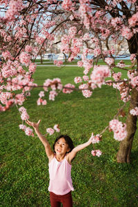 Rear view of woman standing amidst flowers