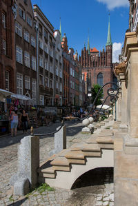 Group of people on street against buildings in city