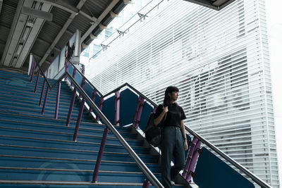 Low angle view of woman standing on staircase