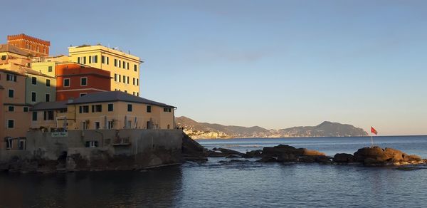 Buildings by sea against sky