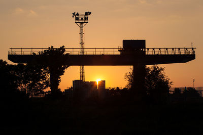 Silhouette bridge against sky during sunset