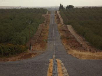 Empty road along countryside landscape