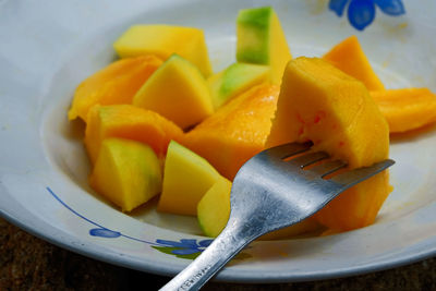 Close-up of chopped fruits in plate on table